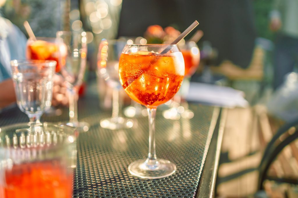 Wine glasses of fresh aperol spritz cocktails
